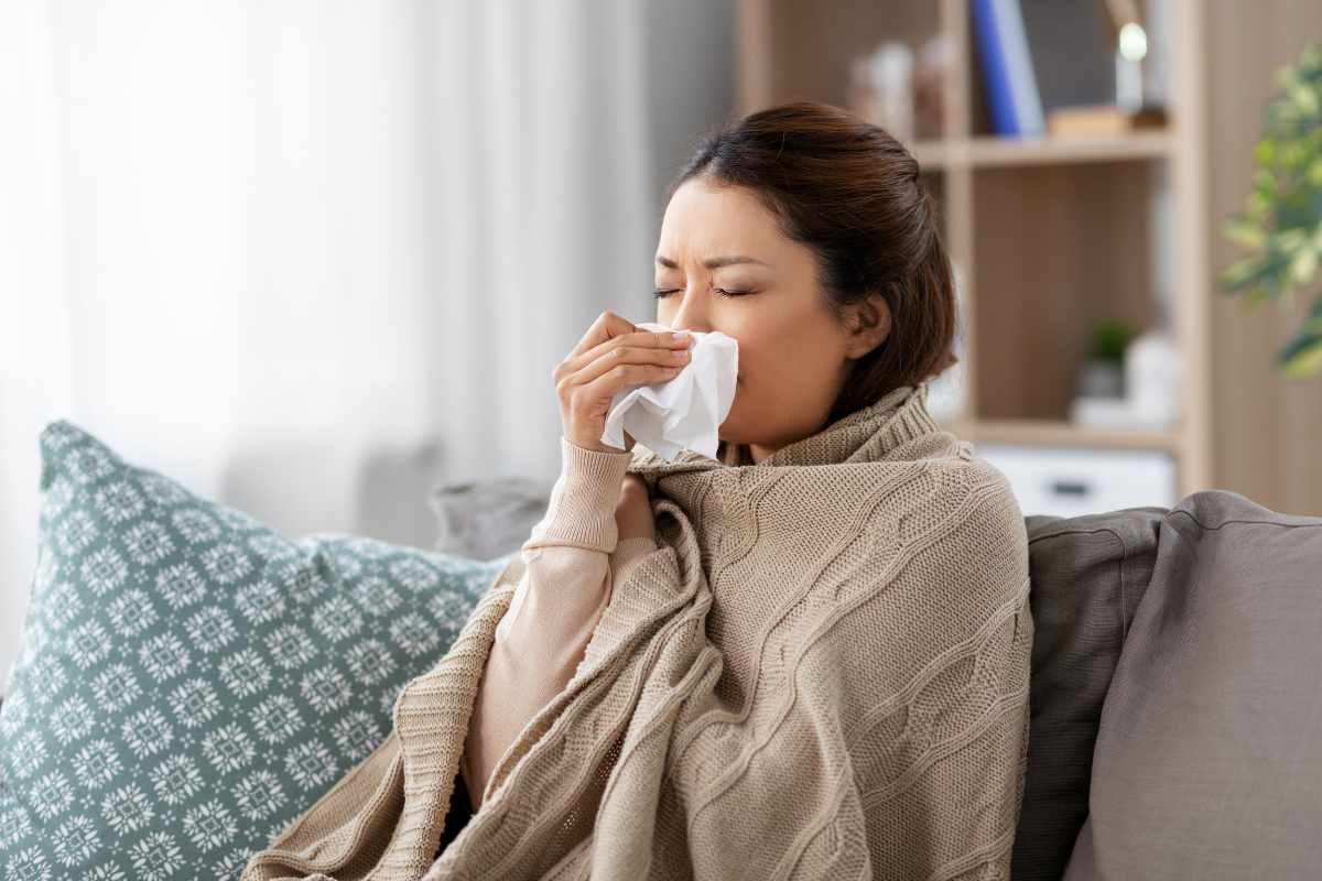 Donna coperta soffia il naso